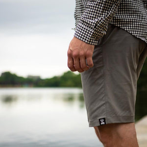 Joob shorts and check shirt looking out at a lake